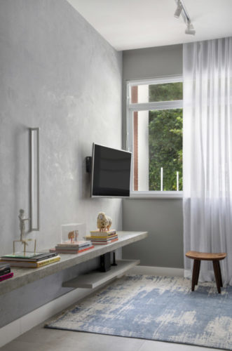 Apartamento compacto - 36m2 muito charmoso em Ipanema, Paredes cinzas , tv na parede e uma cortina de voal branco na janela.