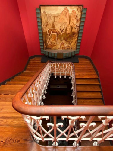 B MAD, Berardo - Museu Art Déco em Lisboa, escada com as paredes laterais pintadas de vermelho e no patamar, uma peça no estilo. 