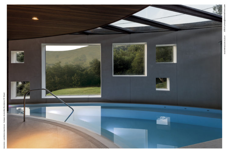 Casa com piscina interna e janelas quadradas para o exterior.