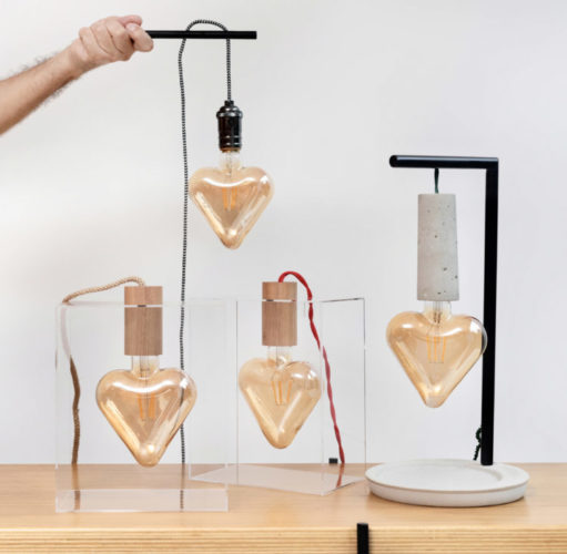 Luminárias com design do arquiteto Ric Melo. Lâmpadas de filamento em formato de coração dentro de uma caixa de acrílico 