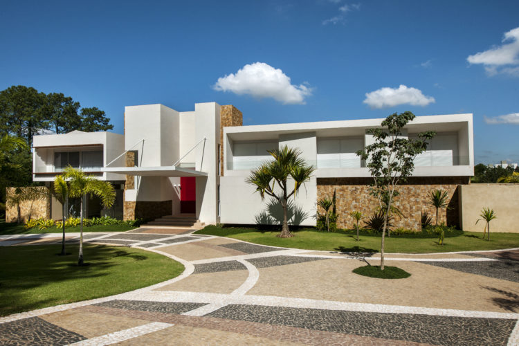 Último projeto residencial do arquiteto e urbanista Noel Marinho em Jundiaí, interior de São Paulo. Casa com estilo arquitetônico modernista, fachada branca com muros de pedra. Volumetria em quadrados e retângulos brancos 