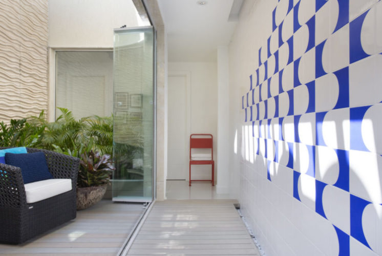 Circulação do segundo andar da cobertura, parede revestida com painel de azulejos na cor azul e branco.