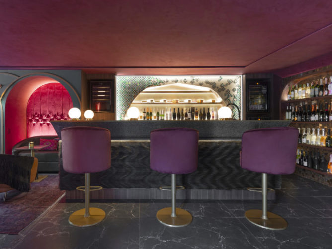CASACOR Santa Catarina 2021. Clima de bar, com ambiente mais escuro, bar com poltronas altas na cor roxo