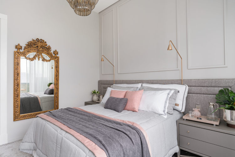 Quarto com decoração clássica. Nas cores cinza, roda e branco e um espelho dourado na parede lateral da cama