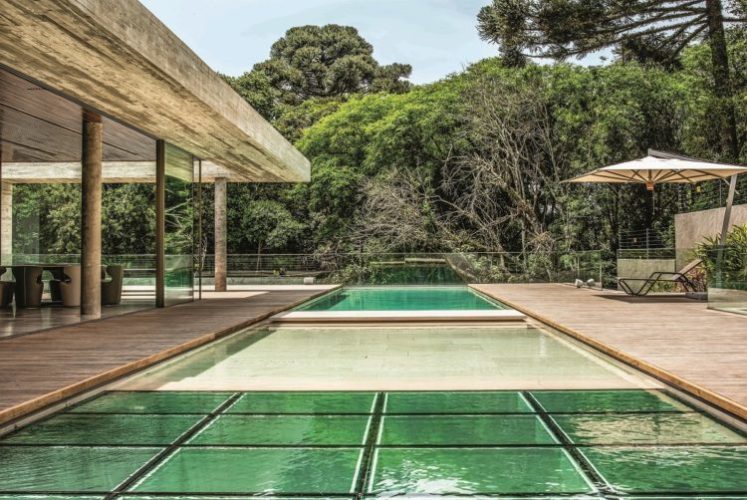 Casa em meio ao verde, com varanda e piscina revestida em pedras naturais