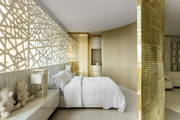 Loft decorado por Brunete Fraccaroli para a CASACORSP21, uma parede curva dourada, em latão, separa a área do quarto 