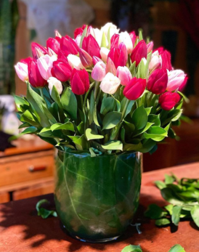 Lindo arranjo de flores, tulipa rosa, em uma vaso com folhagens