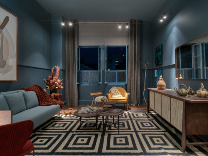 Ambiente da mostra Modernos Eternos em BH. Sala pintada de azul, com sofá azul e tapete preto e branco
