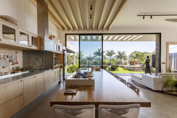 Casa de veraneio com ambientes integrados, janelas de correr integram o exterior. 