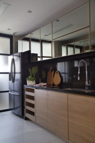 Cozinha com armários em madeira e frontispício de granito preto 