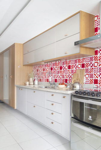 Frontispício da cozinha decorado com azulejos vermelhos e brancos com desenhos gráficos 
