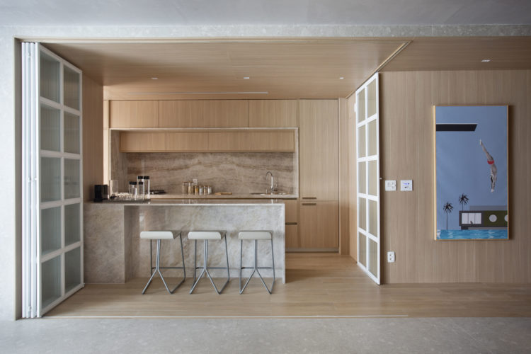 Cozinha integrada a sala, com postas camarão em aluminio branco, e toda revestida em madeira clara, piso, teto e paredes