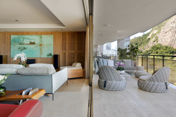 Apartamento com piso em mármore travertino, sala com as esquadrias douradas abertas proporciona integração dos espaços.