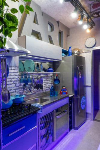 Cozinha com luz azulada, a palavra ART na parede, bancada e geladeira e inox