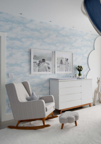 Quarto de bebe decorado nas cores azul e branco. Papel de parede fundo azul com imagens de nuvens 