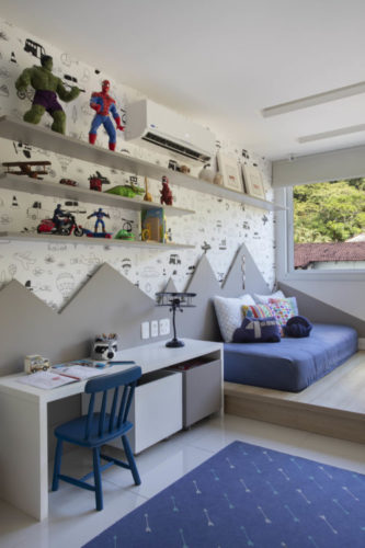 Quarto de menino decorado com papel de parede, apliques de madeira na parede, na cor cinza, tablado com colchão baixo
