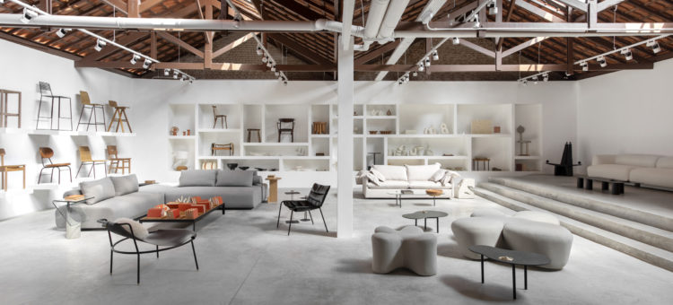 Interior da loja Boobam, paredes na cor branca, piso em cimento claro, valorizando o mobiliário 