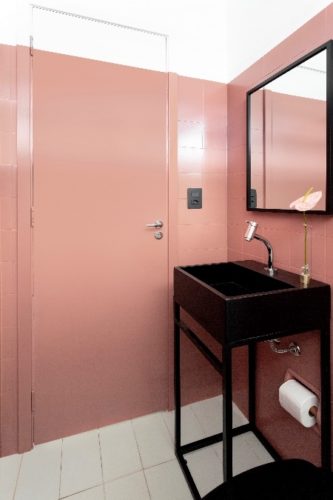 Ambientes molhados: dicas importantes para a pintura de espaços expostos a umidade. Banheiro com os azulejos pintados de rosa , incluindo a porta, deixando apenas uma faixa branca perto do teto