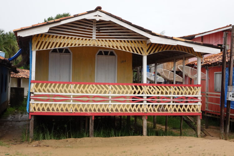 Casa em Belém do Pará, Em madeira, pintada de amarelo e detalhes em vermelho, varanda lateral e acima do chão.