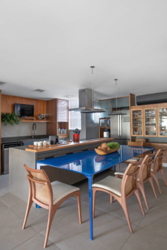 Cozinha integrada a sala, com mesa na cor azul Bic