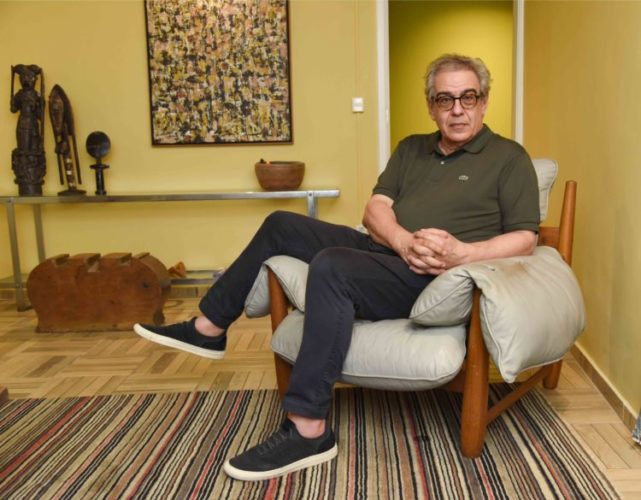 Sergio Zobaran sentado em uma cadeira Mole, de Sergio Rodrigues
