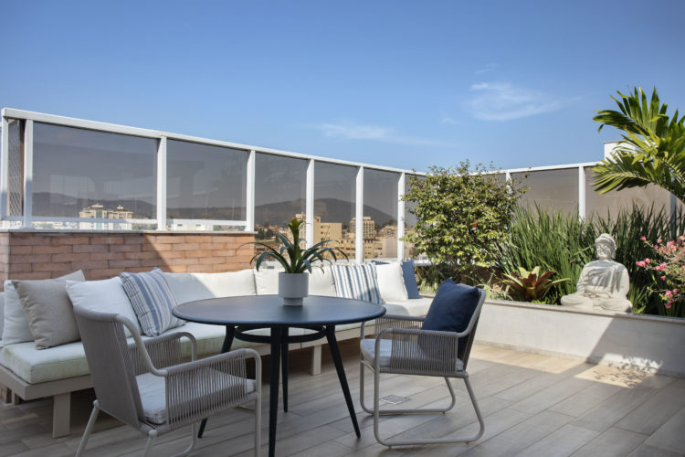 Cobertura linear clara, leve e aconchegante, com terraço. Sofá branco e mesa redonda decorando