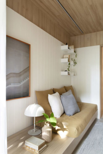 Quarto de hospedes, tablado com colchão, teto em madeira, parede revestida em madeira branca ripada