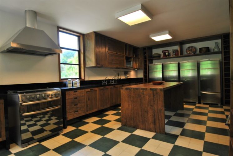 Cozinha com armários e madeira e piso xadrez nas cores verde e branco