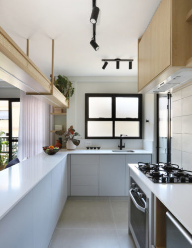 Apartamento com fluidez para interligar ambientes, cozinha aberta para a sala com uma bancada grande na cor branca