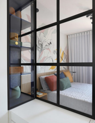 Esquadria preta com vidros separa o closet do quarto