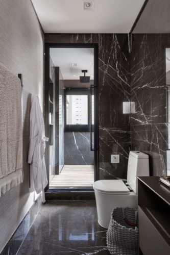 Banheiro com revestimento porcelanato imitando mármore marrom