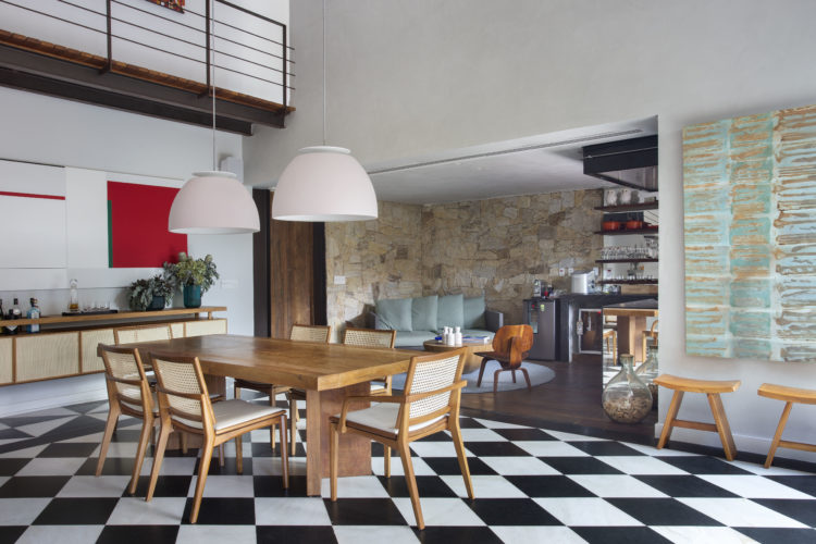 Ambiente de sala de jantar com piso xadrez em preto e branco e pé direito alto, na casa de 790m2 no Jardim Botanico