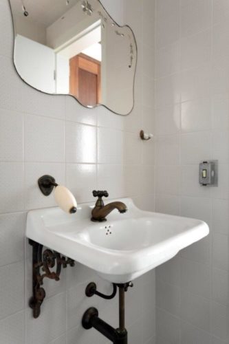 Lavabo com cuba antiga, peça garimpada, e espelho estilo veneziano