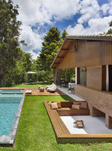 A renovação de uma casa de campo em Teresópolis com 250m2. Área externa da construção em madeira, decl e piscina em forma de raia 