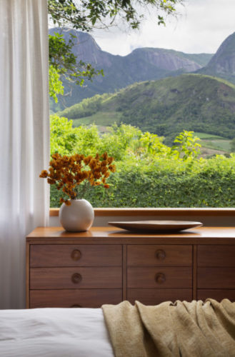 Janela do quarto em uma casa de campo em Teresópolis, com vista para as montanhas.
