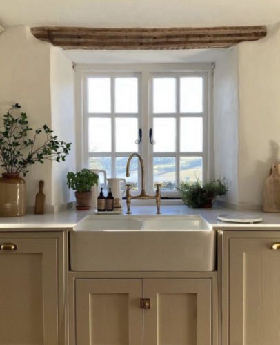 Bancada de cozinha, estilo fazenda, em frente a janela e com uma cuba larga, chamada cuba de saia ou farm sink