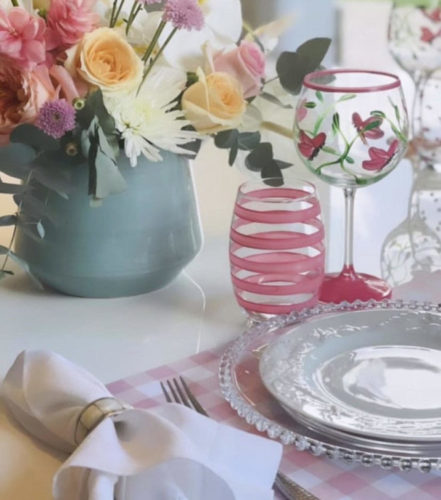 Mesa posta com vaso de flores e copo listrado de rosa pintado á mão.