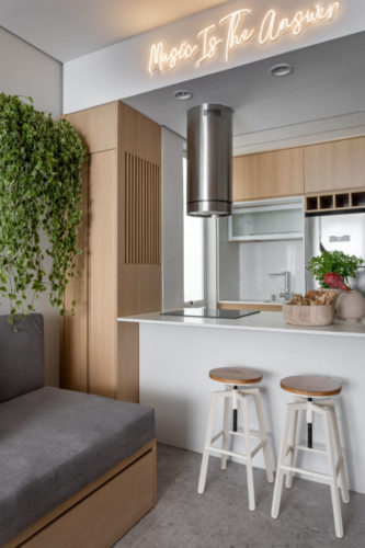 Décor contemporâneo urbano em apartamento com 32m2 em Copacabana. Cozinha integrada a sala, com bancada alta em tampo de corian e duas baquetas