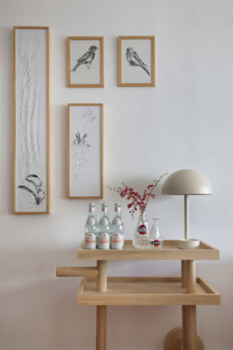 Composição da decoração. Um carrinho de chá para o bar, uma luminária e a composição de pequenos quadros na parede.