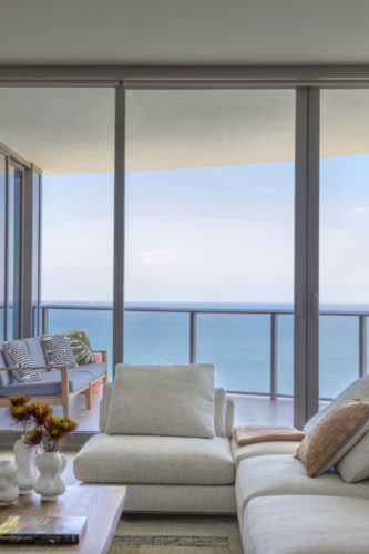 Apê em Miami, de frente para a praia Sunny Isles, andar bem alto, tem varanda e uma vista infinita para o ar