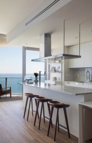 Cozinha totalmente integrada com sala, que tem uma varanda e como é andar alto o apartamento, tem uma vista infinita do mar 