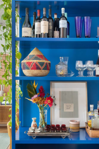 Estante pintada de azul, faz espaço para o bar em casa.