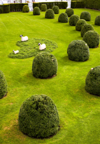Um trio de carneiros/esculturas em um jardim 