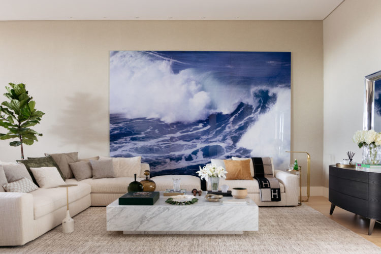 Casa em Miami, decorada em tons neutros, a cor aparece de forma pontual, com destaque para a obra do artista argentino Ignacio Gurruchaga, que reproduz a onda do mar em uma foto de grandes dimensões, apoiada no chão do living, atrás do sofá.