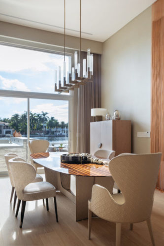 Ambiente da sala de jantar com vista para um canal, nessa casa em Miami