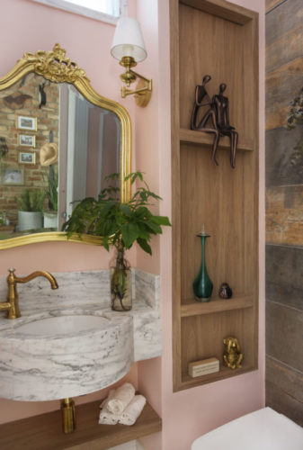 Lavabo decorado com toque retro. Espelho antigo com moldura dourada, arandela da parede e torneiras também antiguinhas e douradas