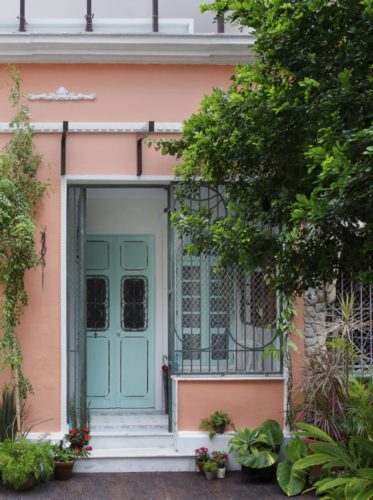 Uma charmosa casa de vila em Niterói, com a fachada pinta de rosa, janelas e portas na cor azul clara, paletas candy colours