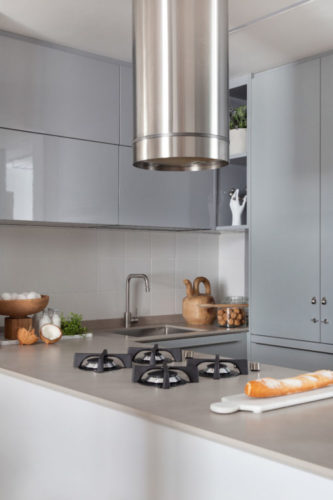 Destaque na cozinha desse apartamento de 60m2, o cooktop Stone Cooking, que permite que os queimadores fiquem em contato direto com a bancada, trazendo uma estética mais limpa do que o habitual;