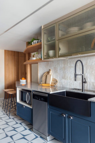 Cozinha com armários inferiores na cor azul, piso em ladrilho hidráulico azul e branco.