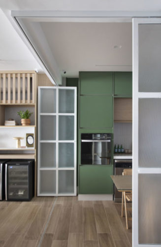 Porta estilo camarão, com vidro jateado e esquadria branca, totalmente recolhida, permite integração total da cozinha com a sala.